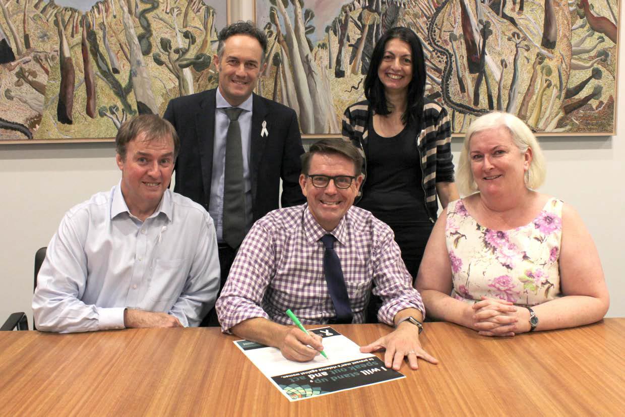 Director-General Dave Stewart signs White Ribbon pledge to stand up and speak out against domestic and family violence.